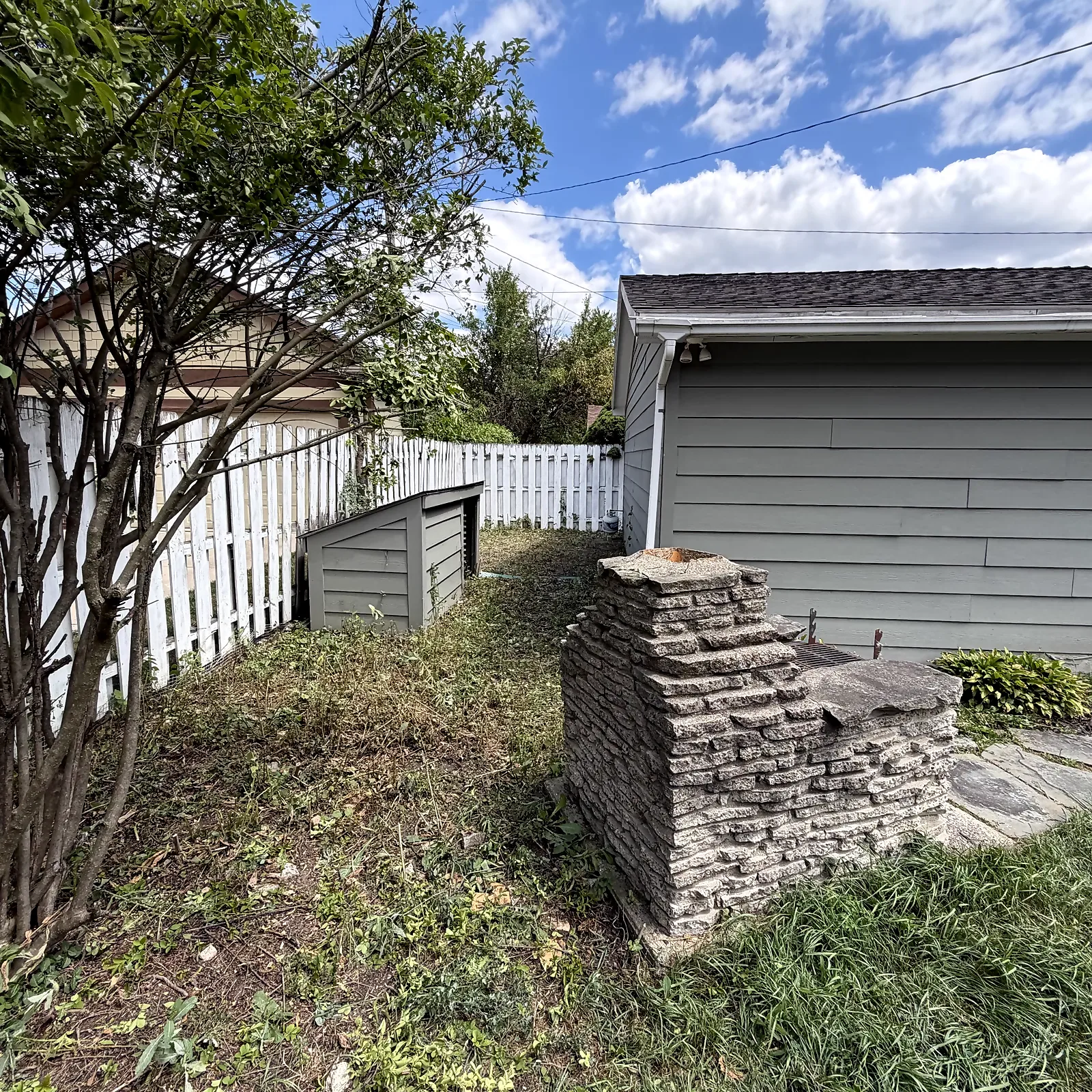 Cleared and trimmed side-yard area at a Royal Oak home after cleanup